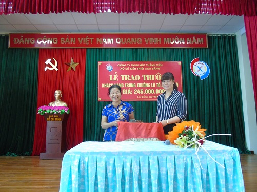 Đ/c Mông Thị Lan - Giám đốc trao tiền thưởng cho khách hàng